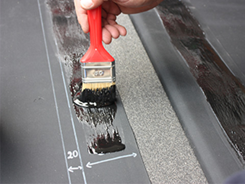 La membrane EPDM est collée à l'aide d'un pinceau