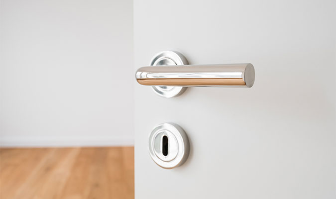 Chrome deurklink op een witte binnendeur